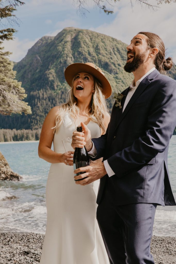 Couple celebrates with champagne at Millers Landing Beach Elopement