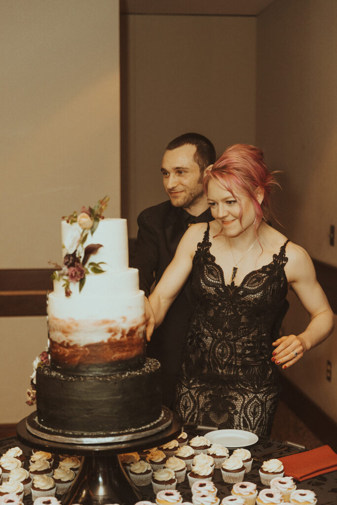 bride and groom cutting their wedding cake 