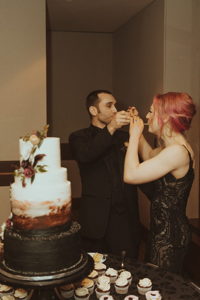 bride and groom trying their wedding cake at their winter elopement