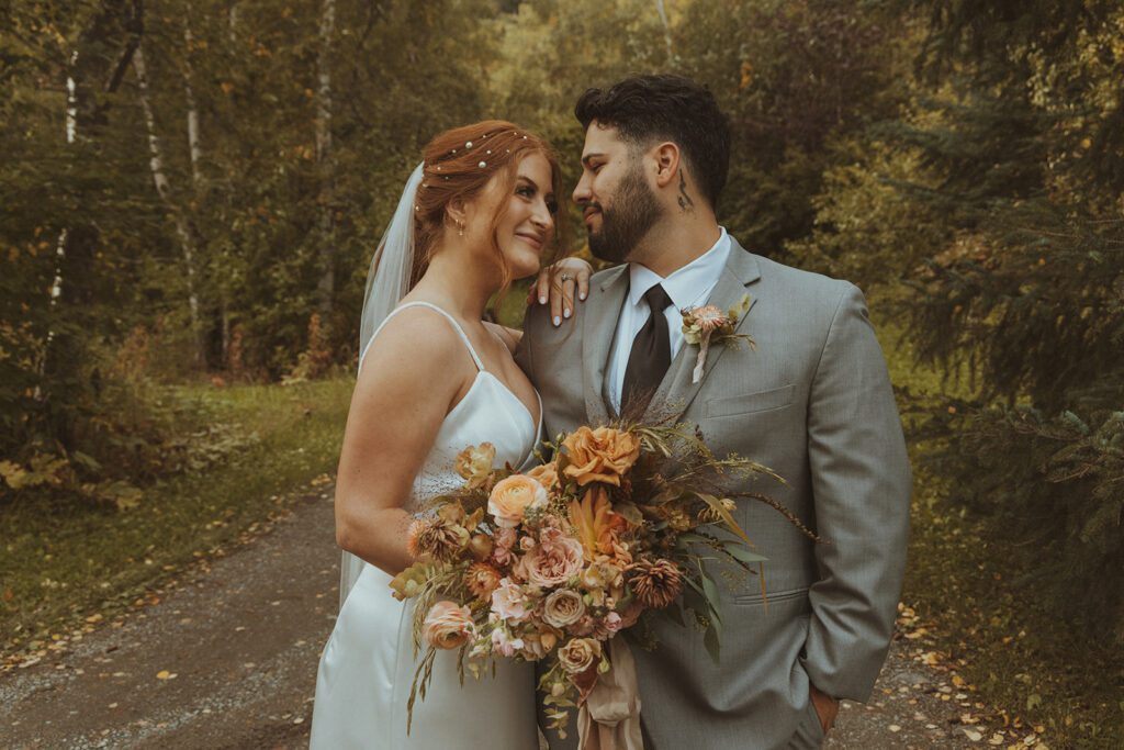 Bride and Groom pose in the fall foliage at Forget Me Not Nursery, Alaska 