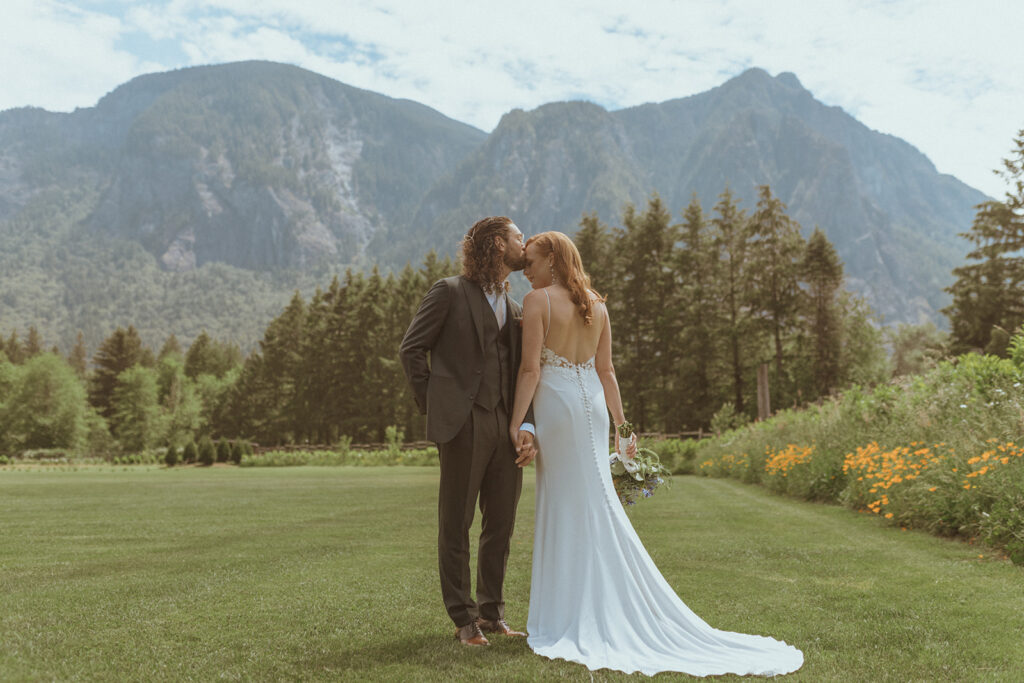 groom kissing the bride on the forehead 