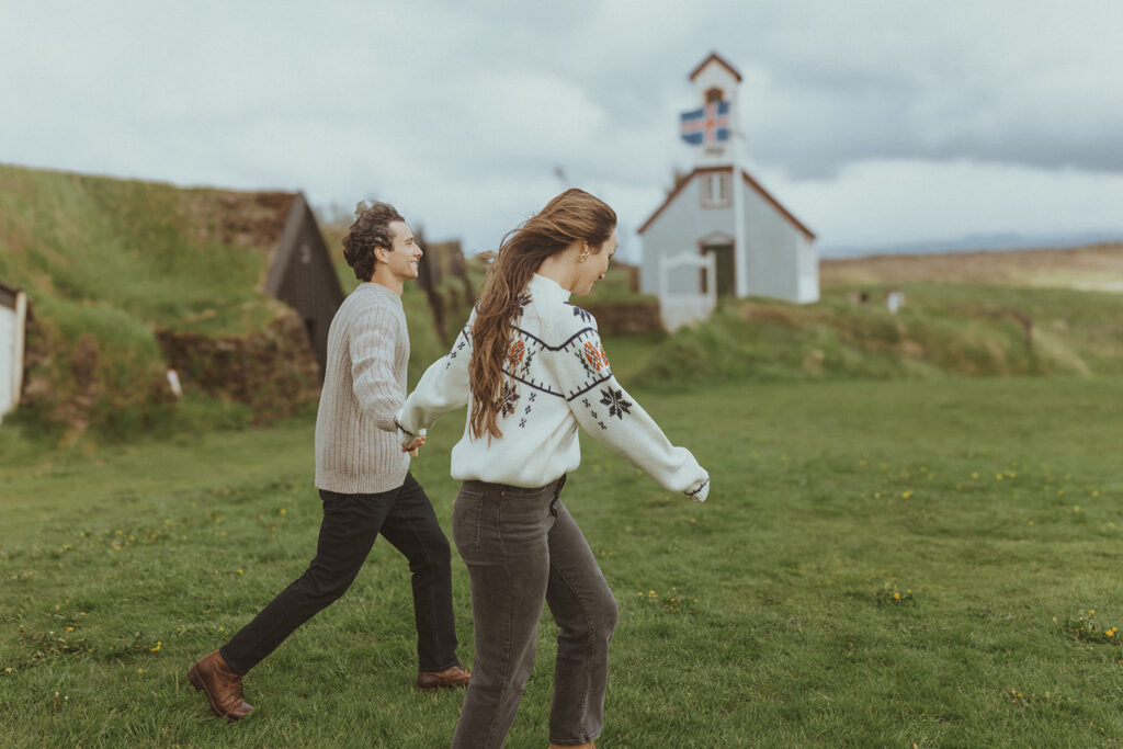 couple walking around one of iceland beautiful turf houses 