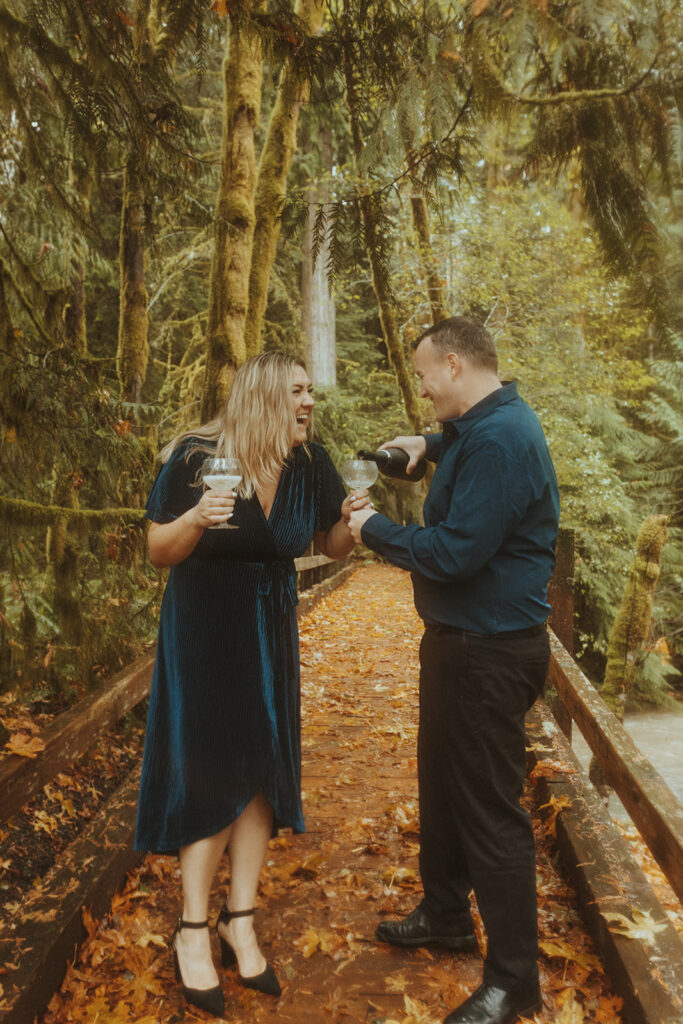 cute couple celebrating their engagement session with champagne 