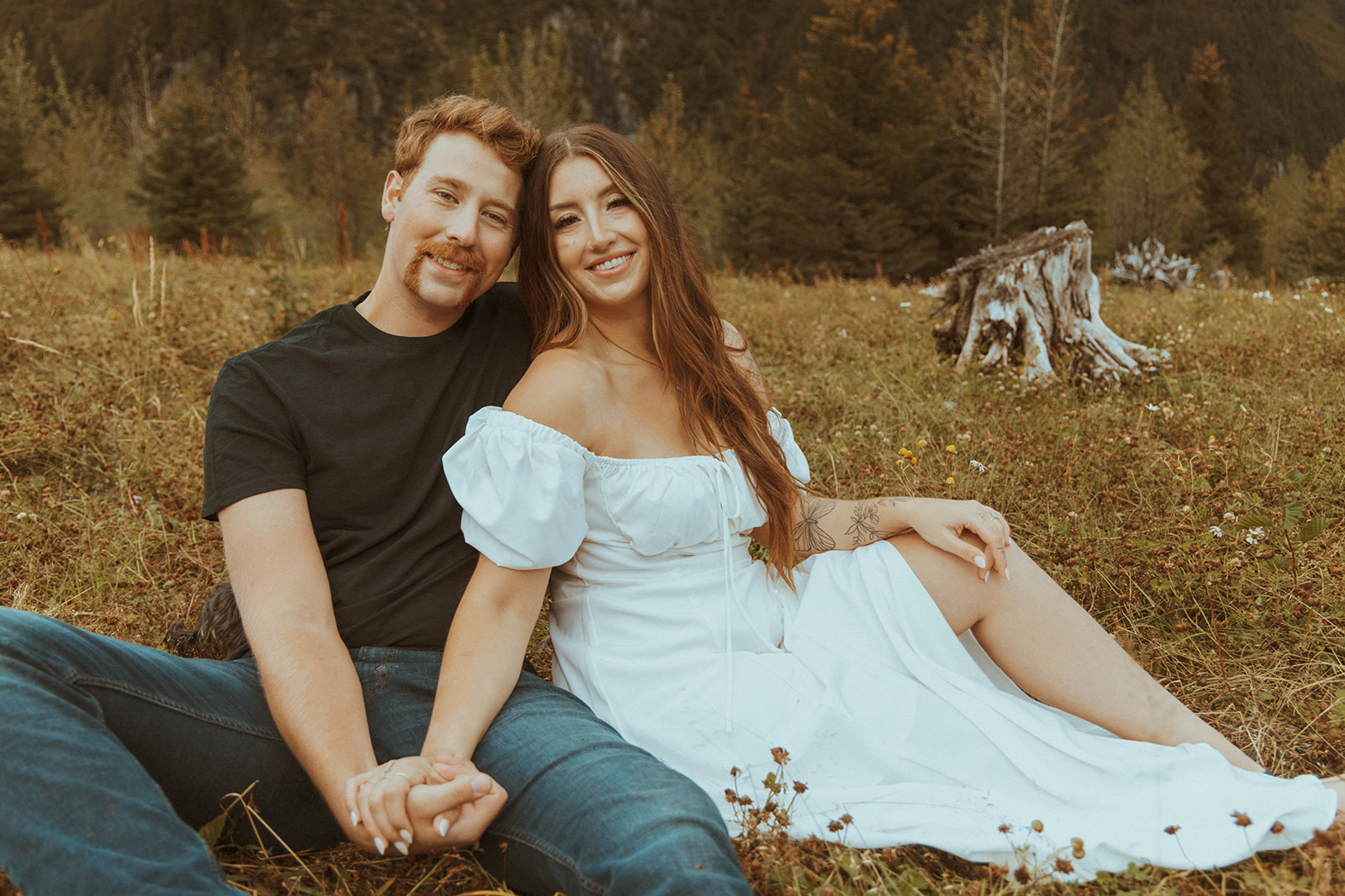 newly engaged couple holding hands looking at the camera during their photoshoot