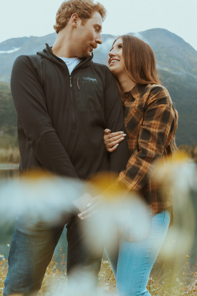 newly engaged couple looking at each other during their whimsical engagement session