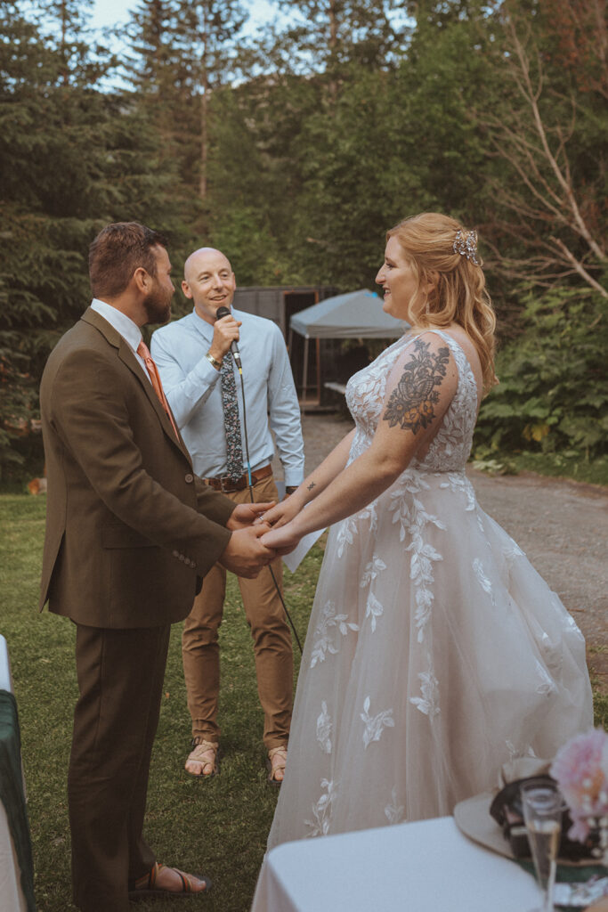 bride and groom holding hands at their ceremony at creekbend cafe in alaska