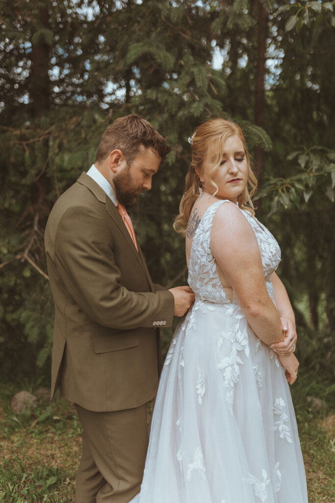 groom helping the bride with her wedding dress