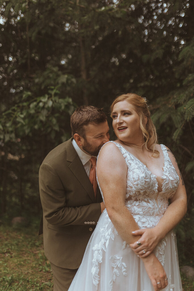 groom kissing the bride on the shoulder 