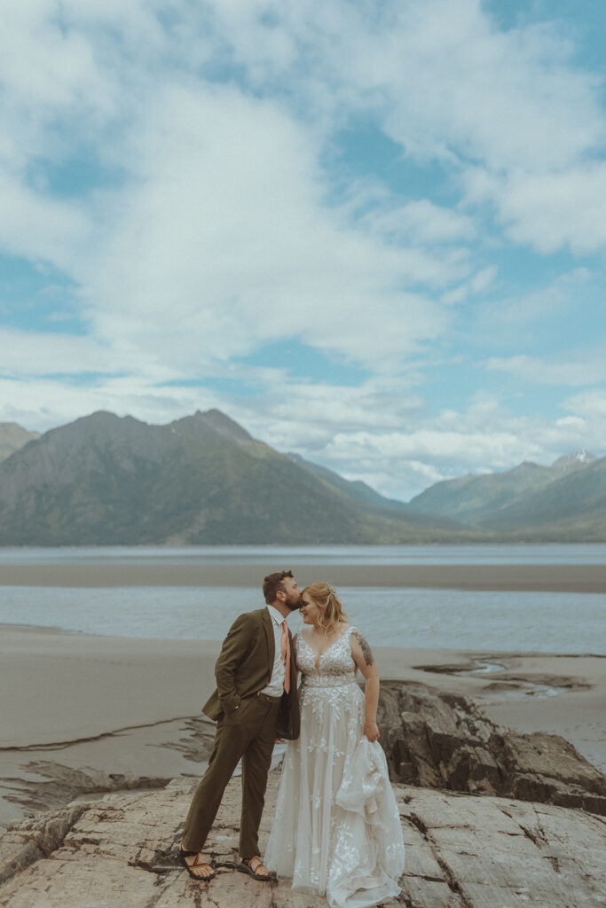 groom kissing the bride on the forehead at creekbend cafe in alaska