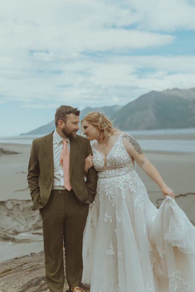 bride kissing the groom on the shoulder 