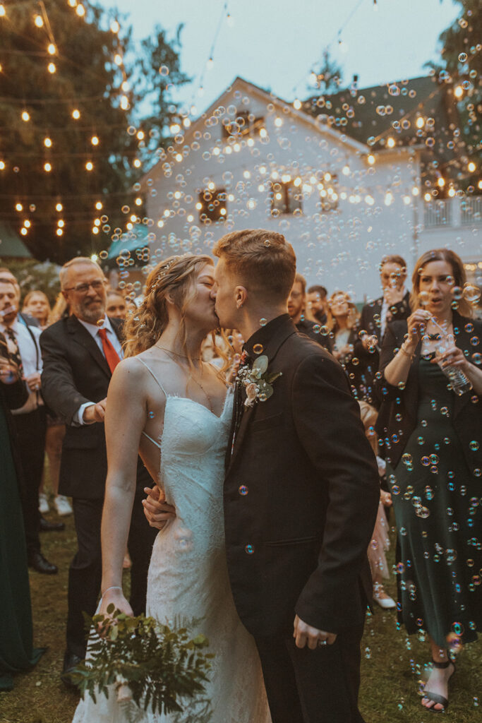 bride and groom kissing during their unique wedding send off ideas