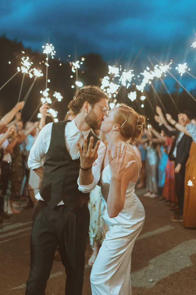 picture of the bride and groom kissing showing their wedding rings 