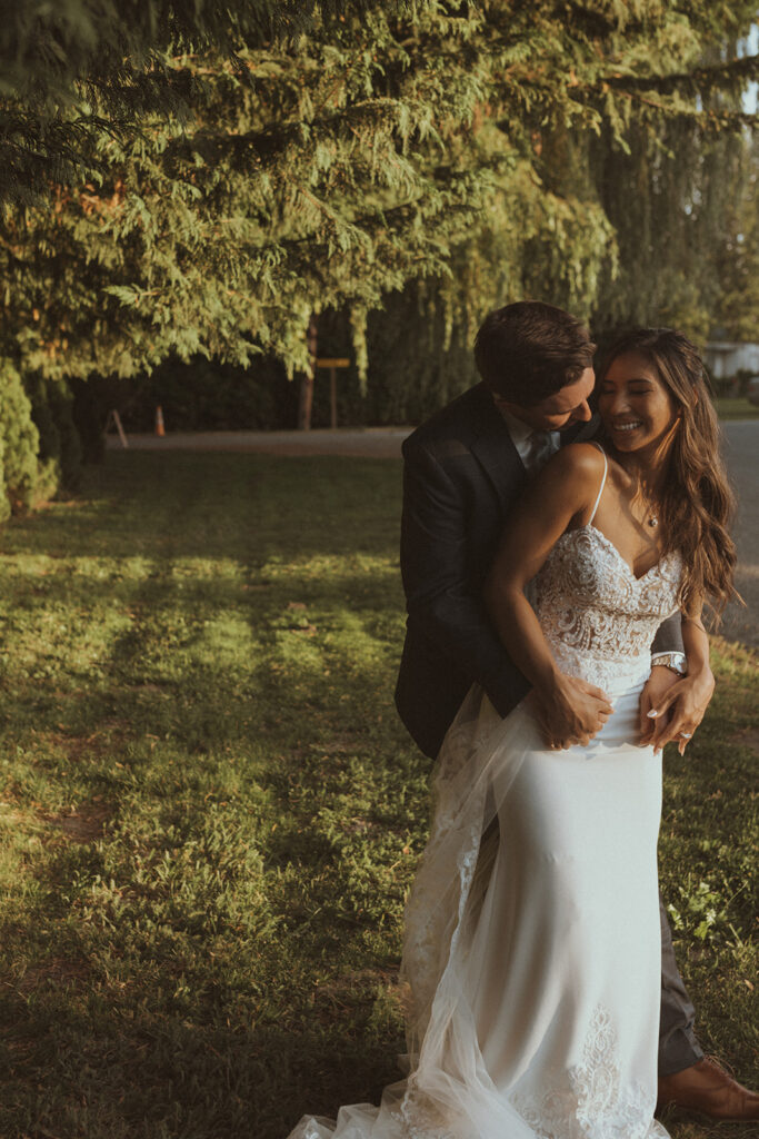 picture of the groom kissing the bride on the shoulder