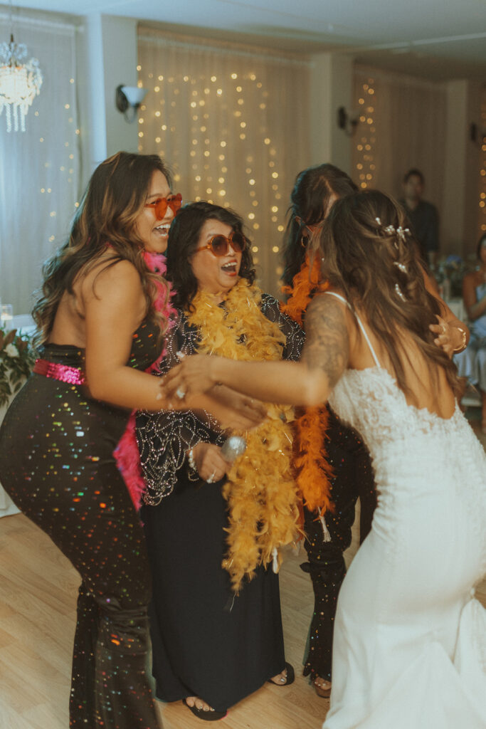 bride hugging with her sisters and her mom