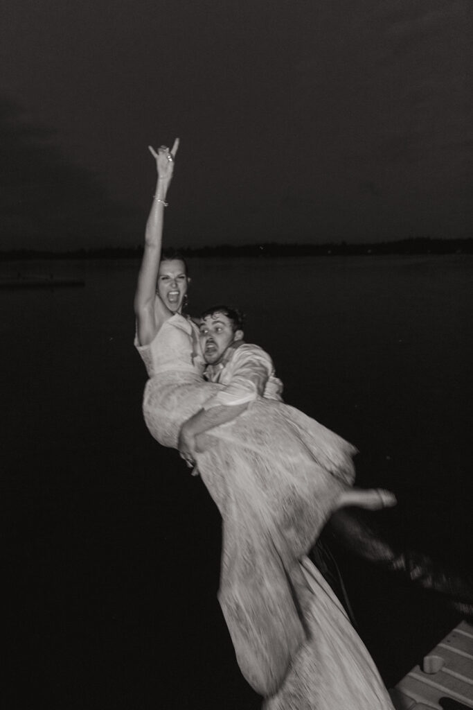 newlyweds jumping on the lake 