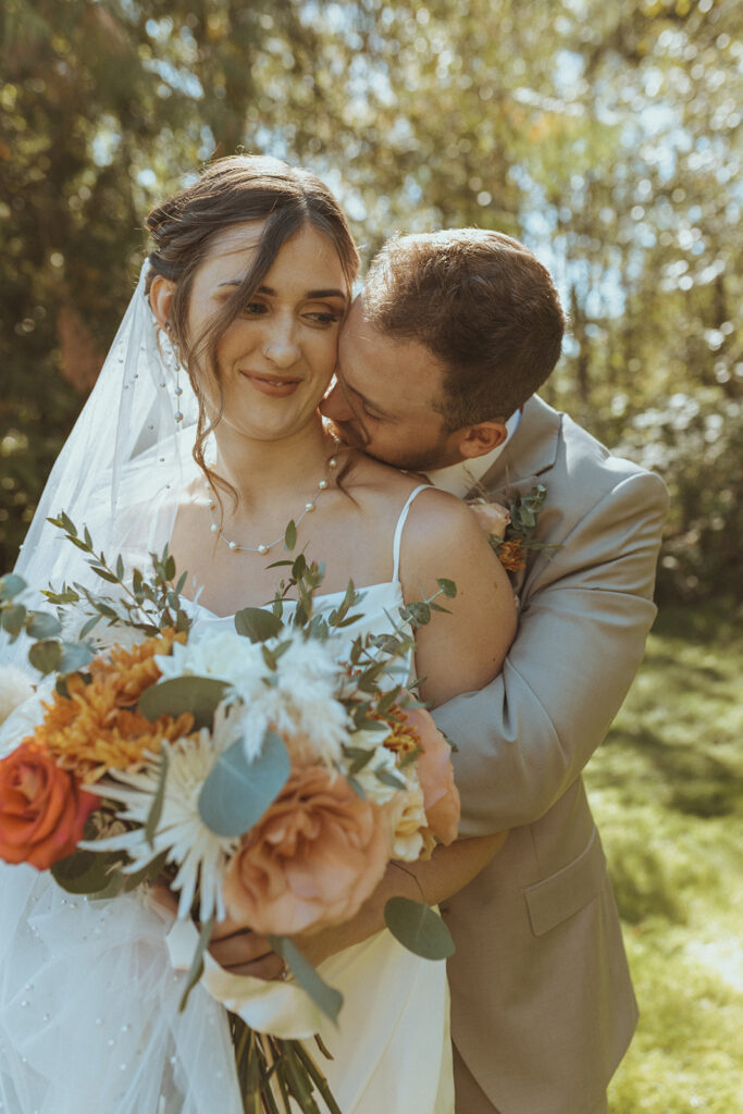 groom kissing the bride on the neck