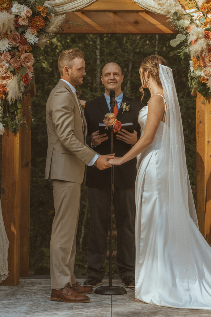 bride and groom holding hands at their wedding ceremony 