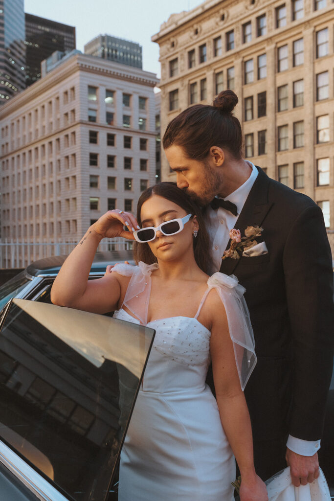 Groom kisses Bride in trendy modern Glasses 