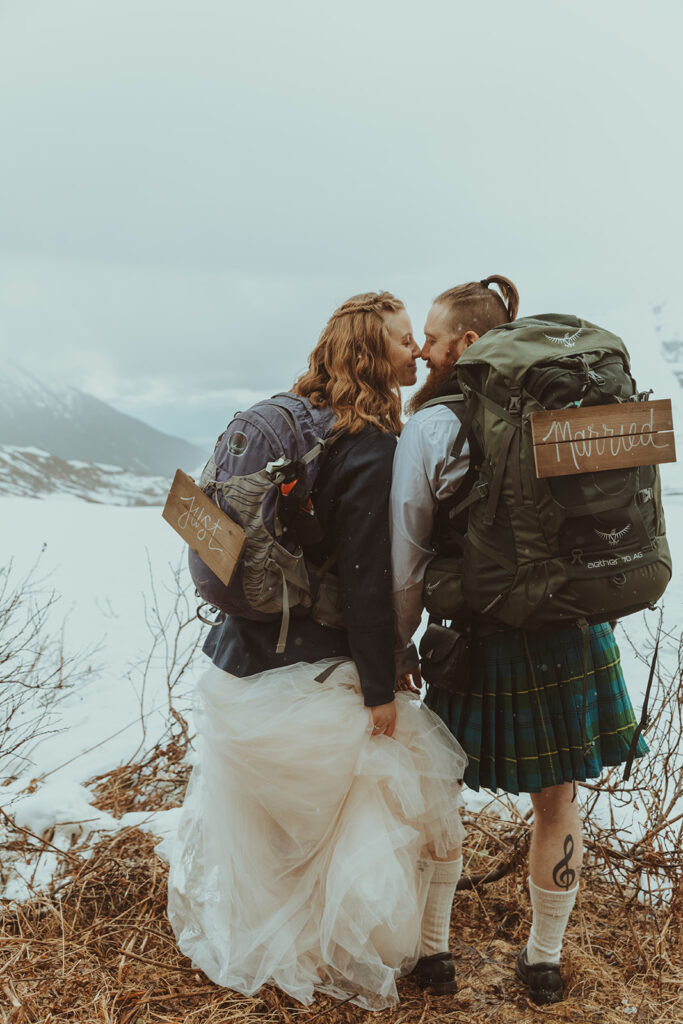 'Just Married' camping sign on bride and groom hiking elopement